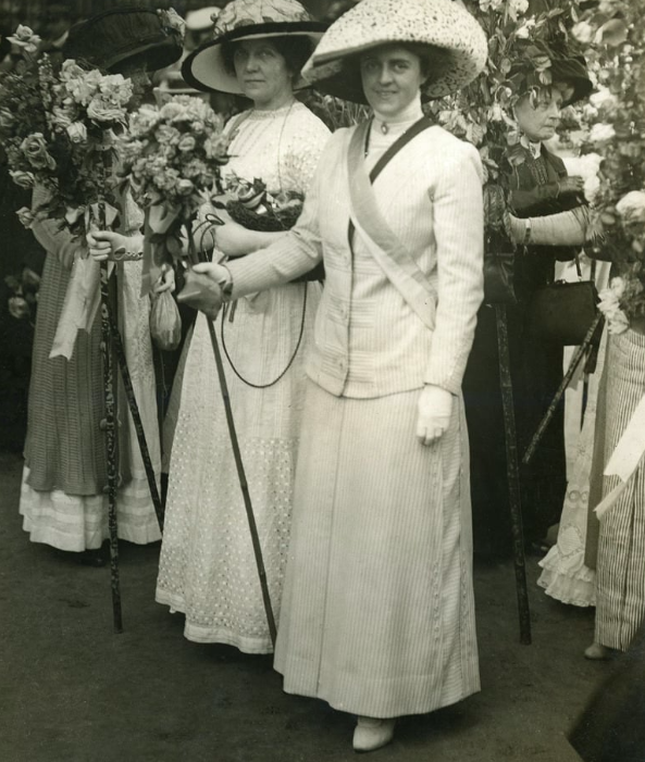Suffragettes holding flowers roots revealed